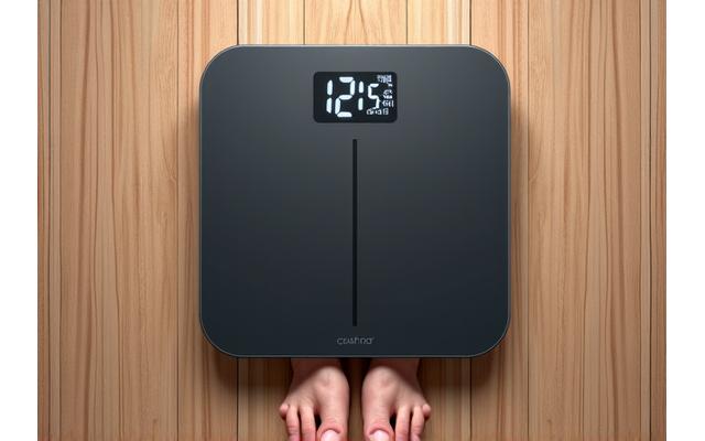 Bilancia intelligente su un parquet di legno, con un display digitale che mostra peso e data, con piedi vicini.